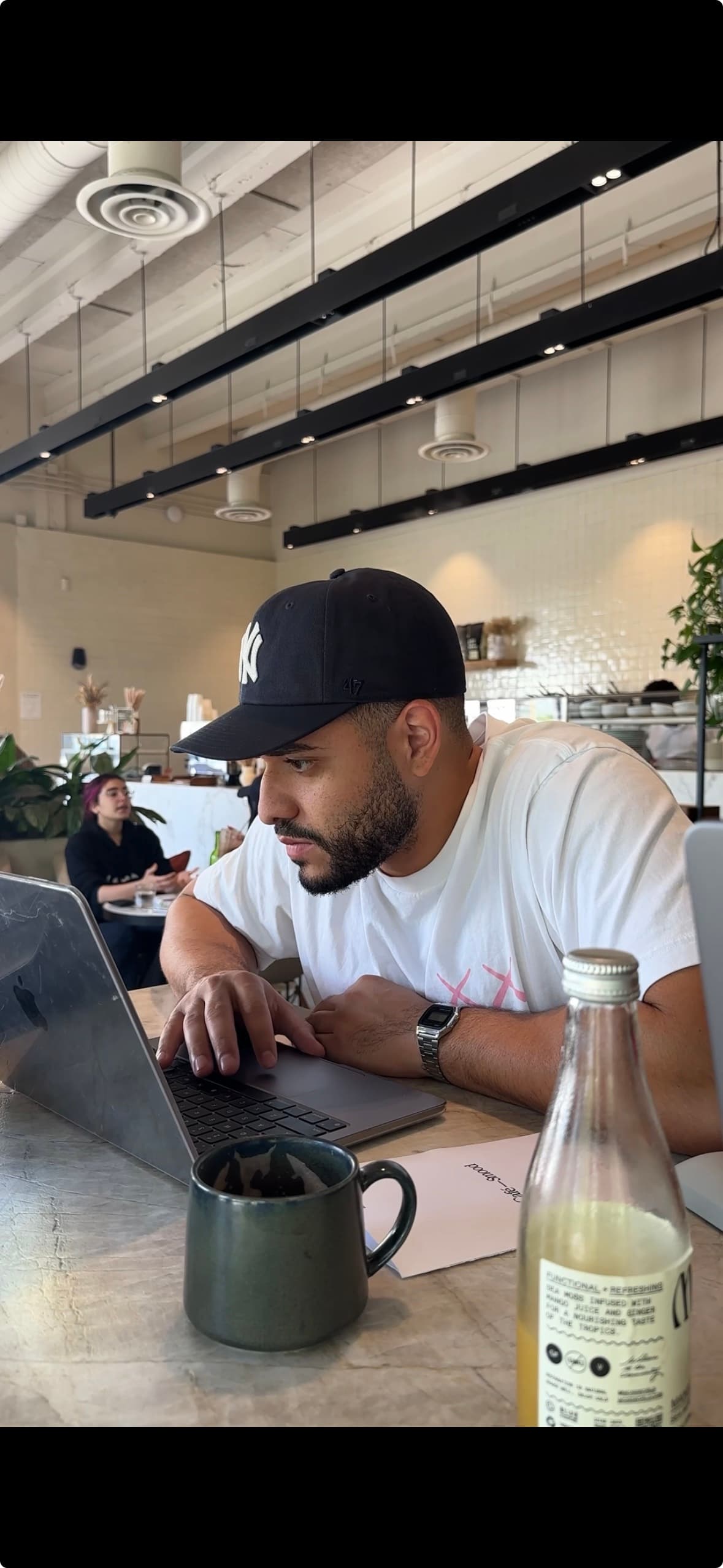 Jonahs Duran working on his laptop at a coffee shop